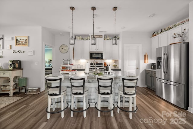kitchen with stainless steel fridge with ice dispenser, dark wood-style flooring, range, and a breakfast bar area