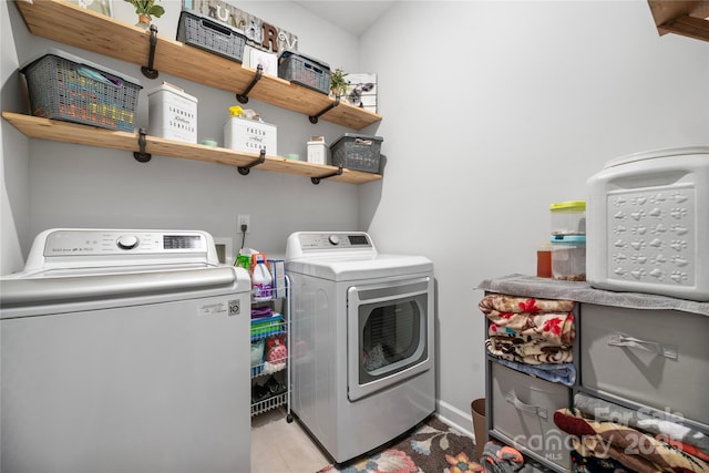 laundry area with tile patterned flooring, baseboards, independent washer and dryer, and laundry area