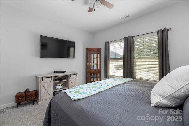 bedroom featuring baseboards, visible vents, light colored carpet, and ceiling fan