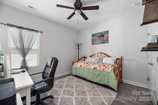 bedroom featuring visible vents, baseboards, wood finished floors, and ceiling fan