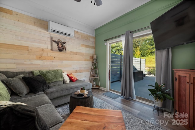 living room with wooden walls, wood finished floors, crown molding, a wall mounted AC, and ceiling fan