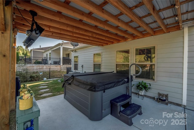 view of patio featuring fence and a hot tub
