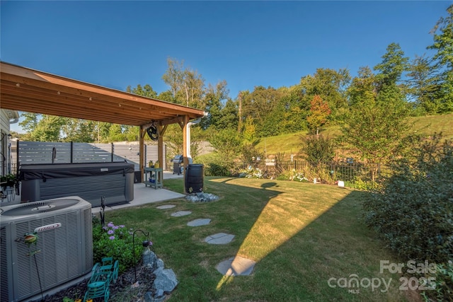 view of yard with a patio area, central AC, a hot tub, and a fenced backyard
