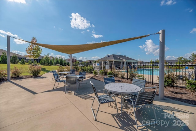 view of patio / terrace with fence, a community pool, and outdoor dining space