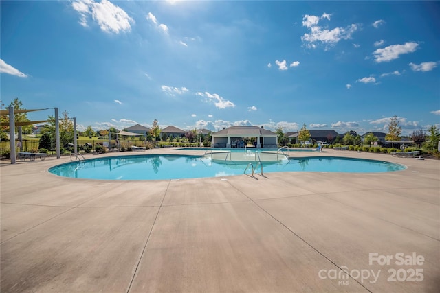 pool with a patio and fence