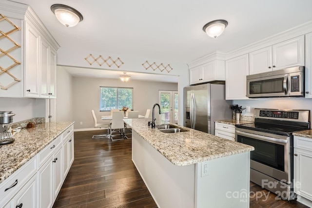 kitchen with white cabinets, an island with sink, sink, dark wood-type flooring, and stainless steel appliances