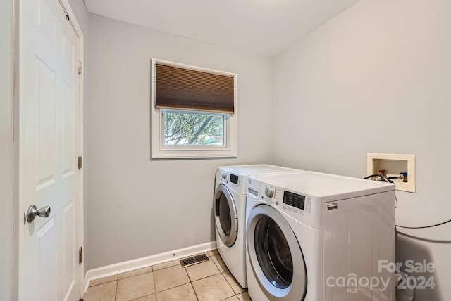 washroom featuring washer and dryer and light tile patterned flooring