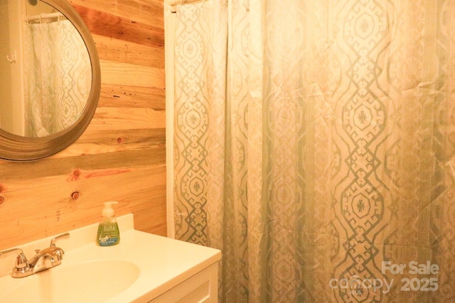 bathroom with vanity and wood walls