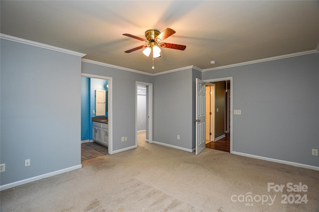 unfurnished bedroom with carpet, ceiling fan, ornamental molding, and ensuite bath