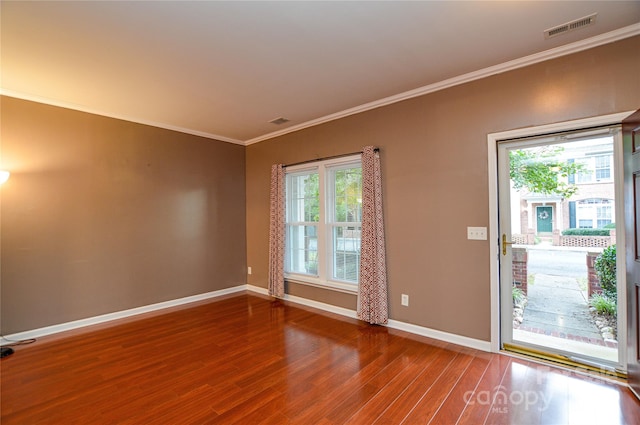 empty room featuring crown molding and hardwood / wood-style floors