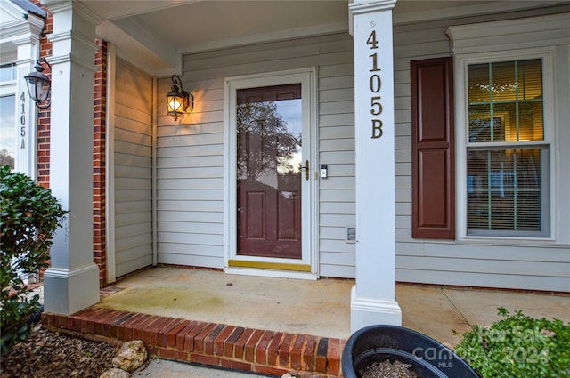 view of exterior entry featuring covered porch