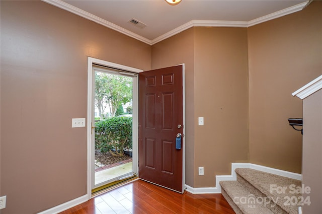 foyer with ornamental molding and hardwood / wood-style flooring