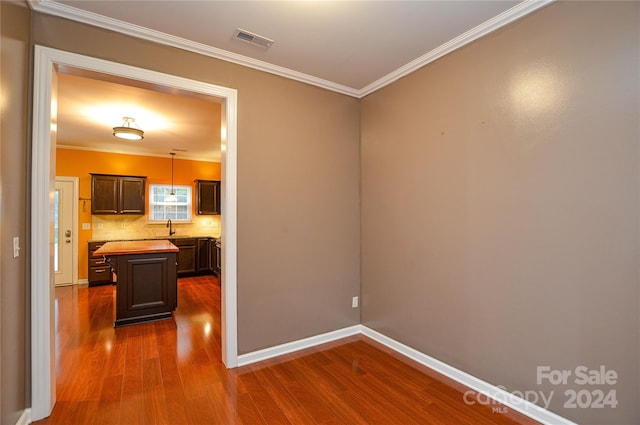 spare room with dark hardwood / wood-style floors, ornamental molding, and sink