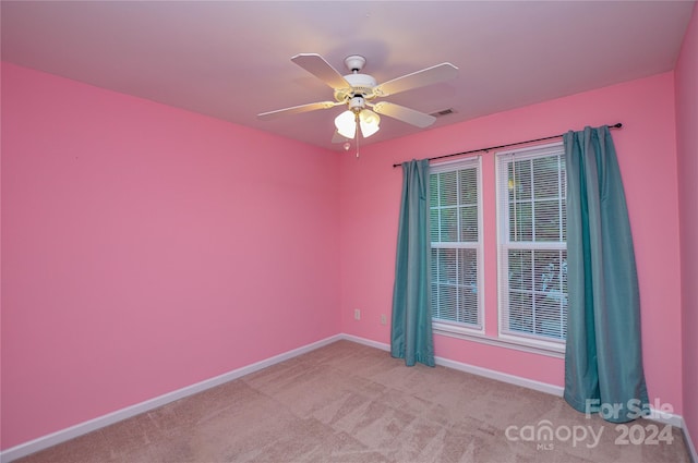 spare room featuring light carpet and ceiling fan