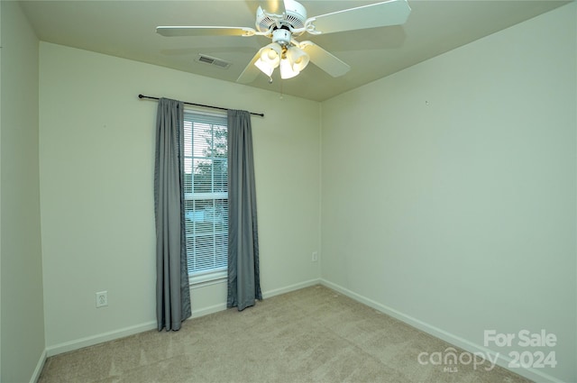 carpeted spare room with ceiling fan