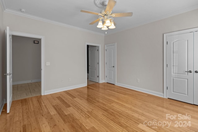 unfurnished bedroom featuring ornamental molding, light wood-style flooring, and baseboards
