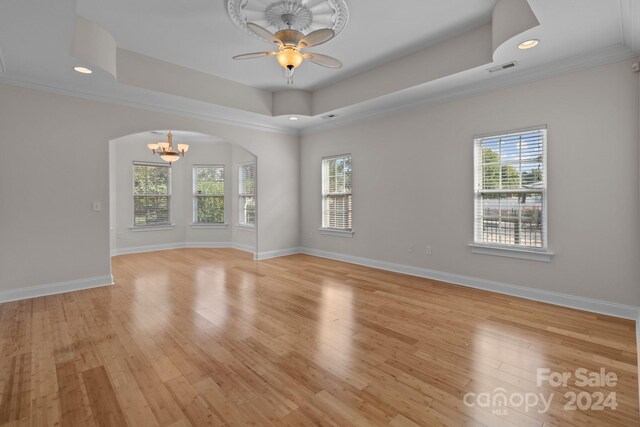 unfurnished room with light wood-type flooring, a healthy amount of sunlight, and crown molding