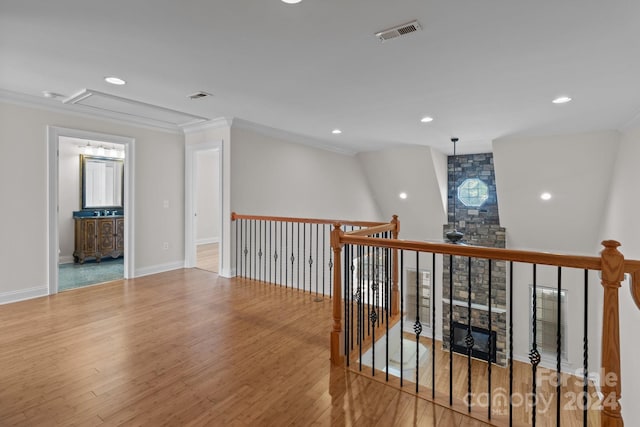 corridor with light hardwood / wood-style flooring and crown molding