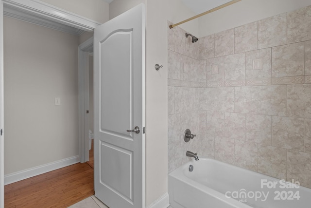 bathroom with tiled shower / bath and hardwood / wood-style flooring