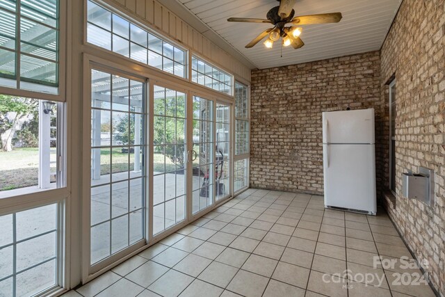 unfurnished sunroom with wooden ceiling and ceiling fan