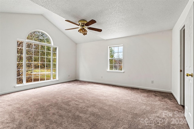 carpeted empty room featuring a textured ceiling, plenty of natural light, lofted ceiling, and ceiling fan