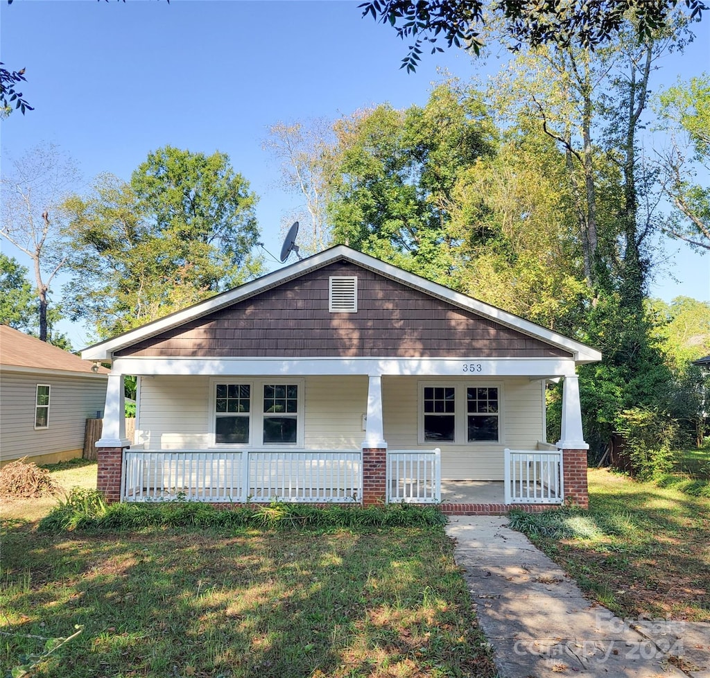 view of front of home featuring covered porch and a front yard