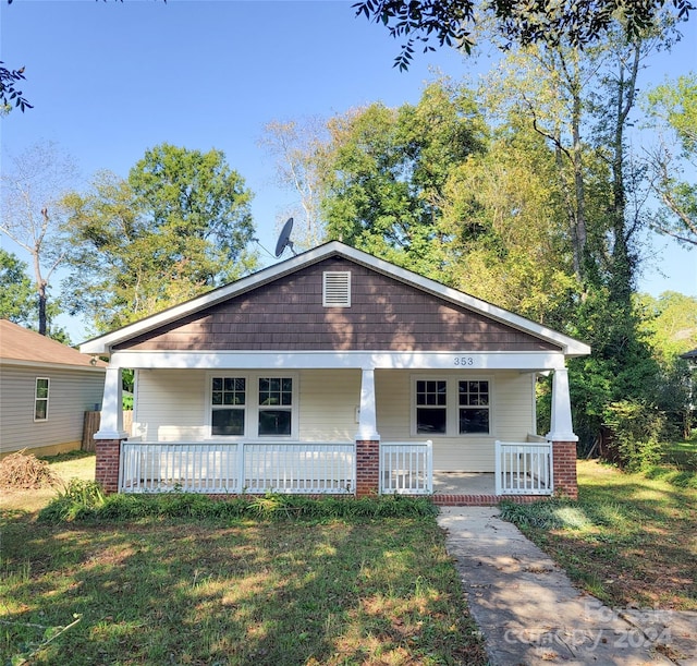 view of front of home featuring covered porch and a front yard