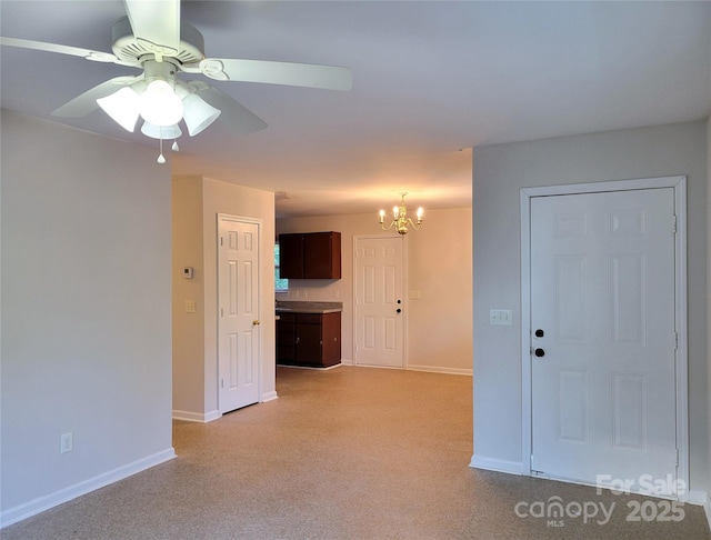 empty room with ceiling fan with notable chandelier