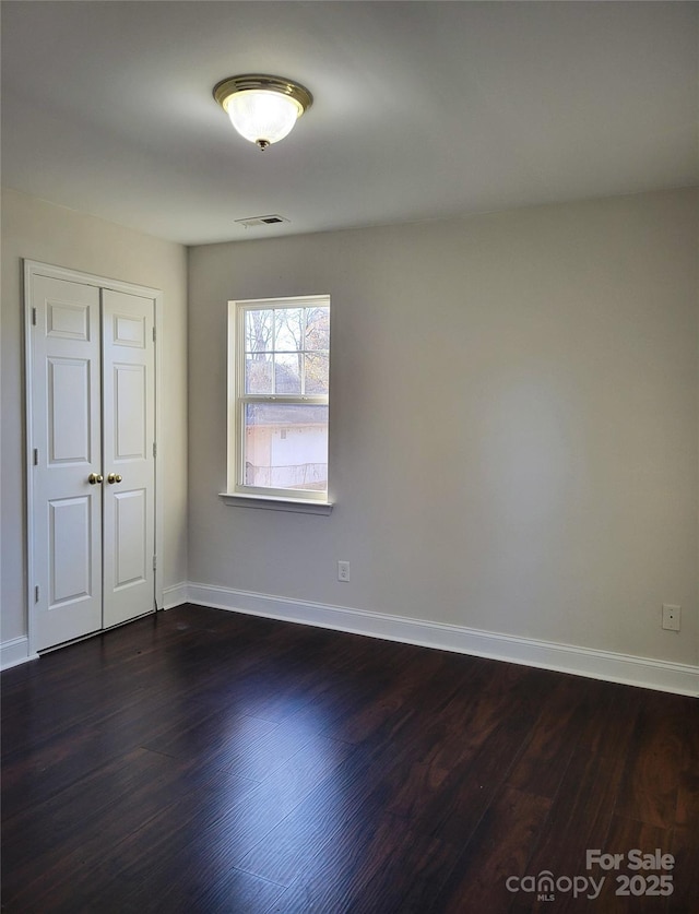 empty room featuring dark wood-type flooring