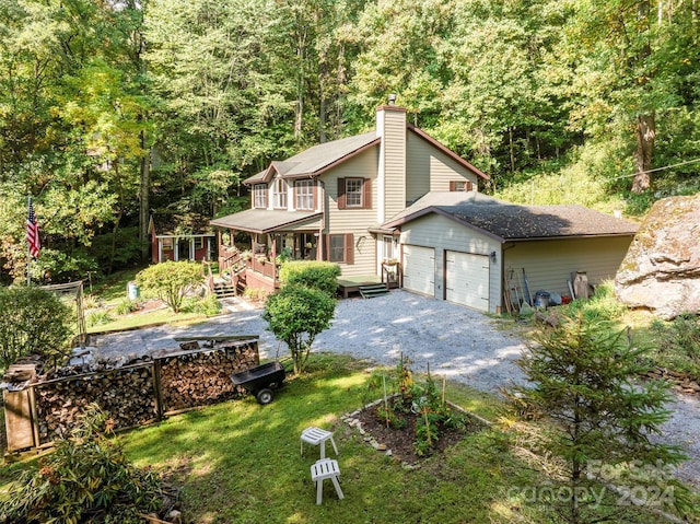 front facade with a garage, a wooden deck, and a front lawn