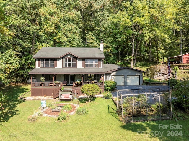 view of front of house featuring a garage, a front lawn, and an outbuilding