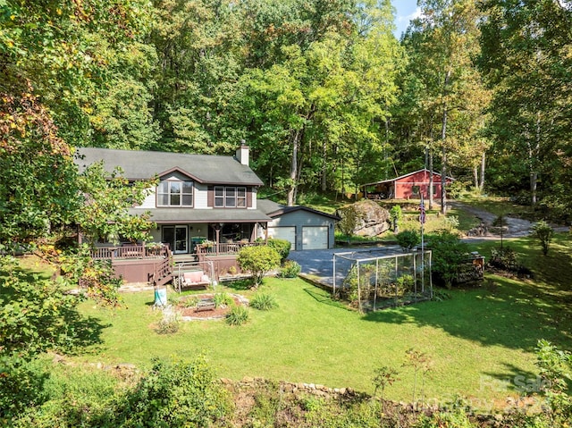 exterior space featuring a garage, a deck, and an outbuilding