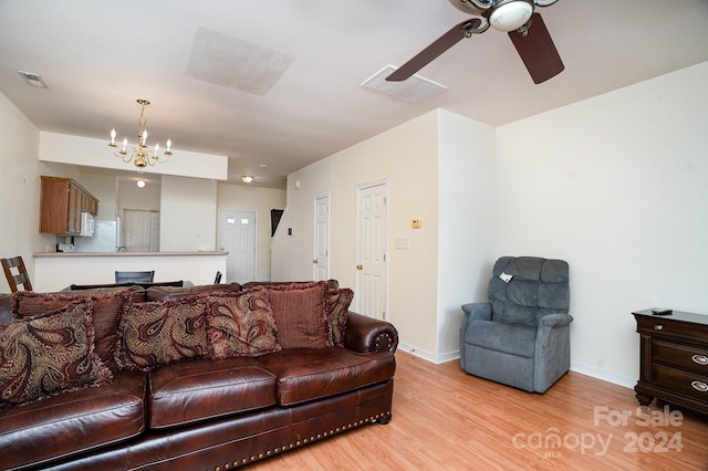 living room featuring ceiling fan with notable chandelier and light hardwood / wood-style floors