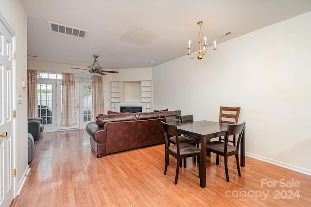 dining room featuring light wood-type flooring and ceiling fan with notable chandelier