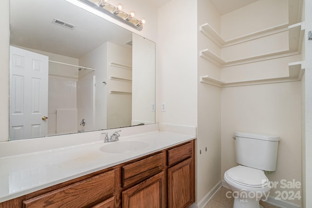 bathroom featuring vanity, a shower, and toilet