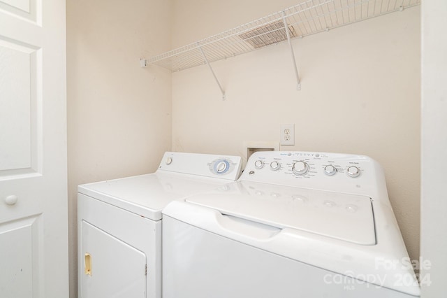 clothes washing area featuring independent washer and dryer