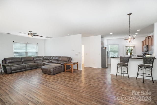 living room featuring dark hardwood / wood-style floors, a wealth of natural light, and ceiling fan