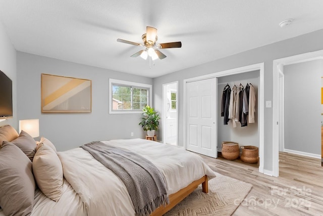 bedroom with a closet, ceiling fan, and light wood-type flooring