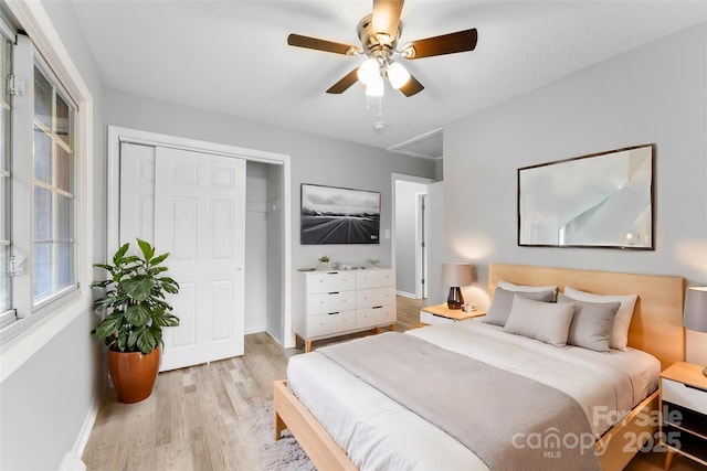 bedroom featuring light hardwood / wood-style flooring, a closet, and ceiling fan