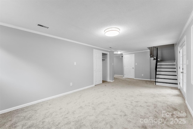 basement with ornamental molding, carpet floors, and a textured ceiling