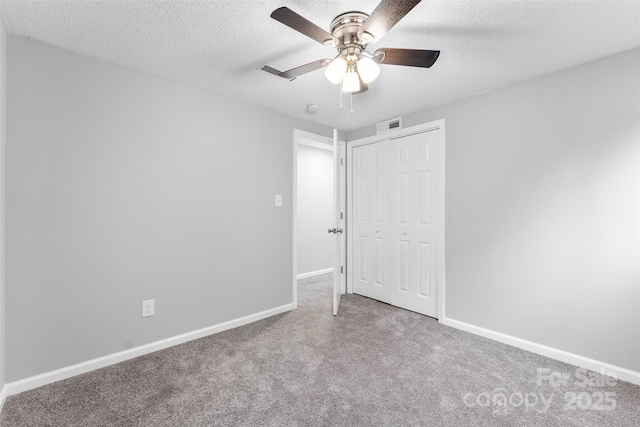 unfurnished bedroom with ceiling fan, carpet flooring, a closet, and a textured ceiling