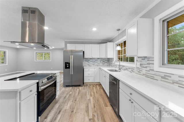 kitchen featuring stainless steel appliances, island exhaust hood, sink, and white cabinetry