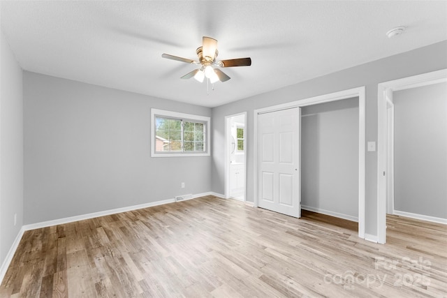 unfurnished bedroom with ceiling fan, light hardwood / wood-style floors, and a closet