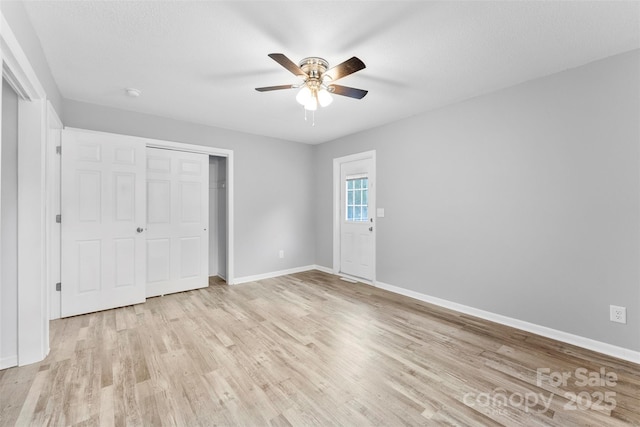 unfurnished bedroom featuring light hardwood / wood-style floors, a closet, and ceiling fan