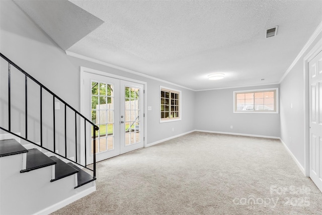 interior space featuring french doors, ornamental molding, light carpet, and a textured ceiling