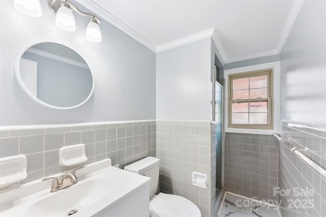 bathroom with tile walls, vanity, crown molding, and toilet