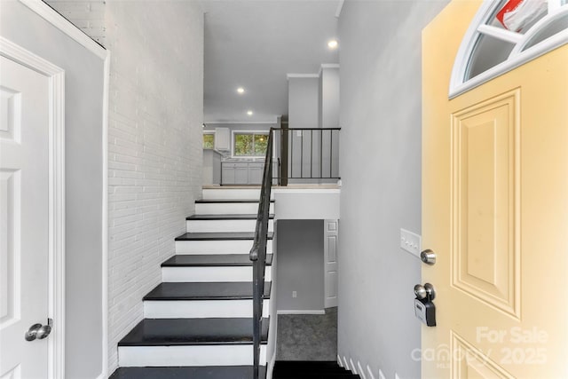 stairway featuring brick wall