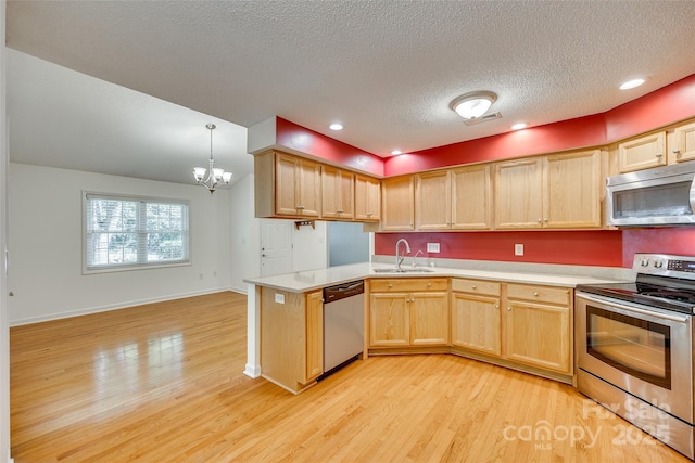 kitchen featuring kitchen peninsula, light brown cabinetry, stainless steel appliances, pendant lighting, and light hardwood / wood-style flooring