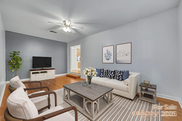 living room with ceiling fan and light hardwood / wood-style flooring