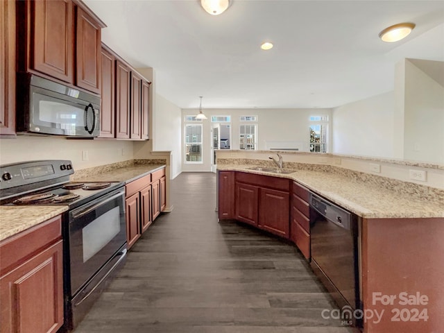 kitchen featuring pendant lighting, black appliances, dark wood-type flooring, and sink